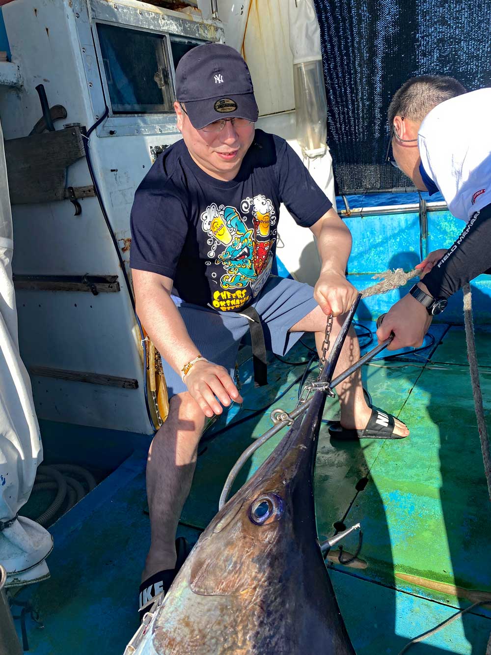カジキを船に引き上げている新潟の二人の男性