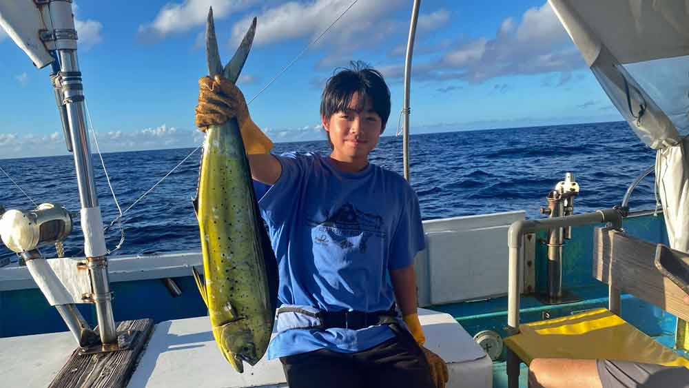 シイラを持ち上げている中学生