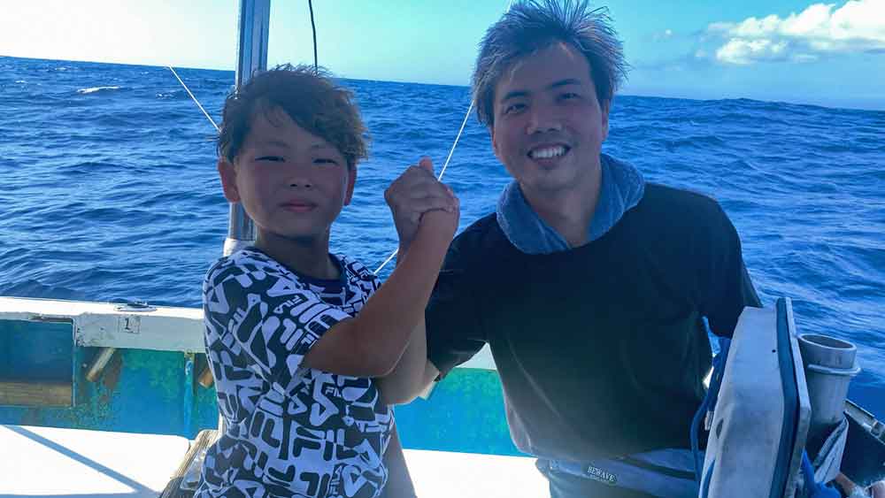 バショウカジキ釣り上げ父と手を握り喜ぶ小学校4年生の少年