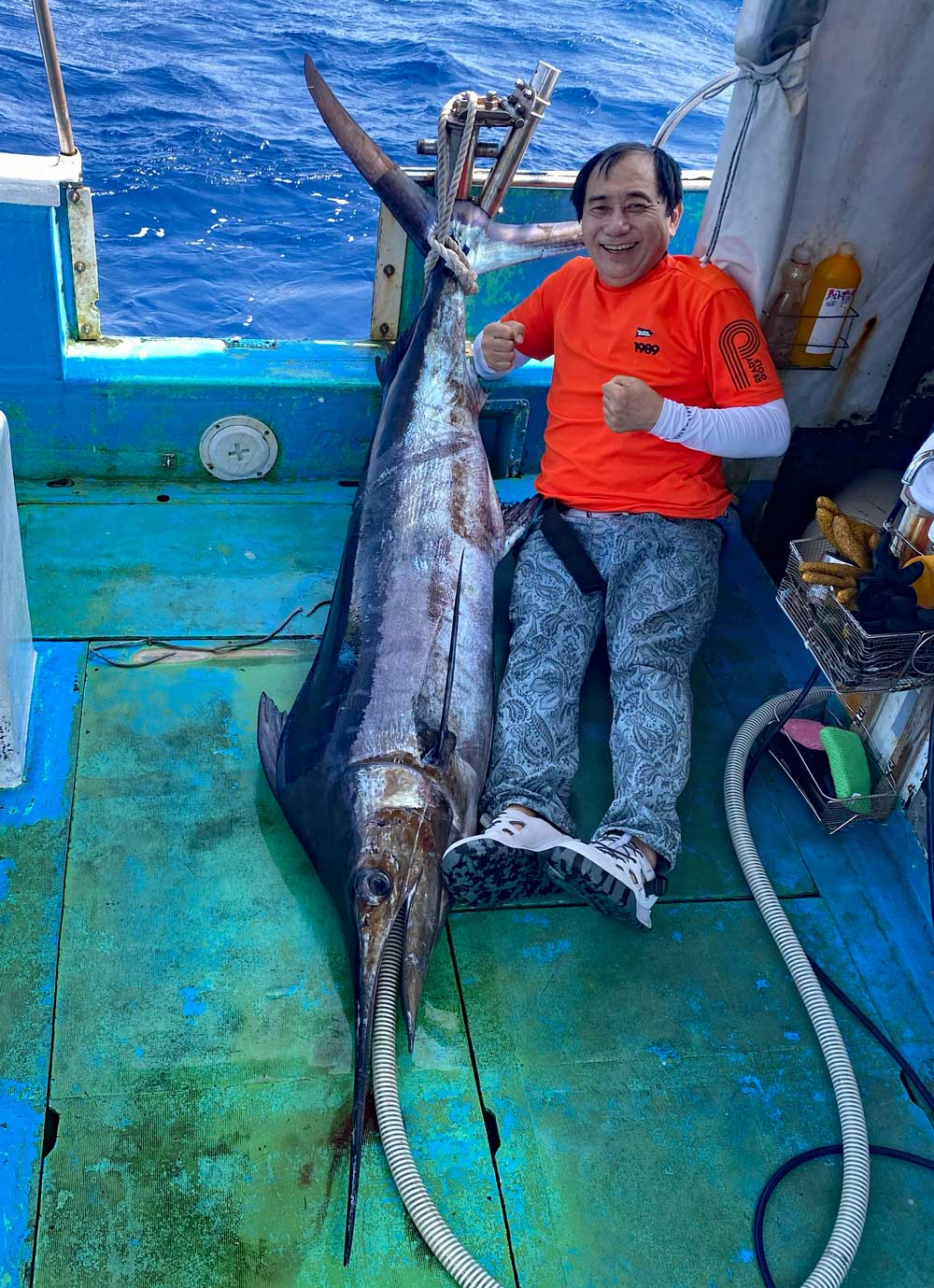 カジキを釣り上げ喜んでいる男性